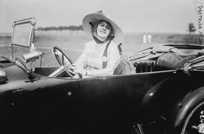 Lady in wide hat sits in Automobile, vintage photo