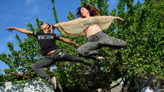 young girl and boy jumping outdoor