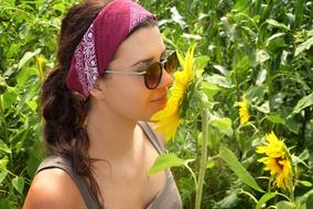 Girl smelling Sunflower in Field