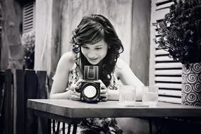 Black and white photo of the beautiful, smiling girl, taking a photo, in Vietnam