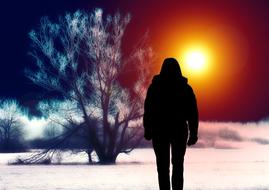 silhouette of a lonely man on a winter evening field