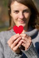 girl holding a paper heart in her hand