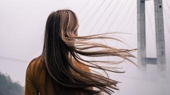 girl with long hair on the background of the bridge architecture