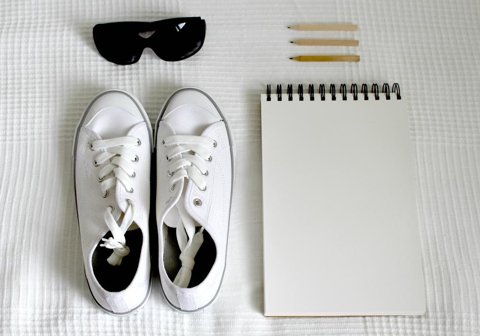 Beautiful, white shoes, black sunglasses, notebook and pencils as a pack for holidays