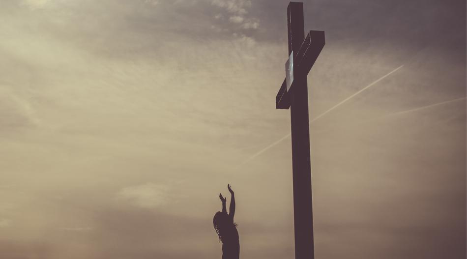 woman praying near the cross