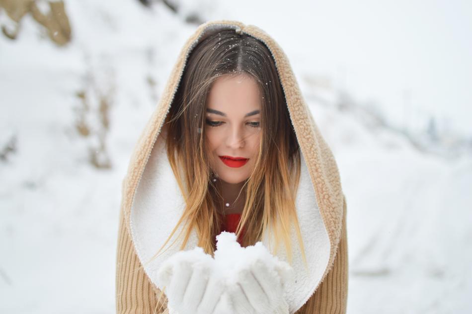 girl with red lips in a hood posing in nature