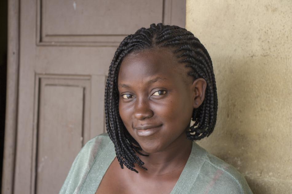 Portrait of the beautiful woman with pigtails, posing near the door