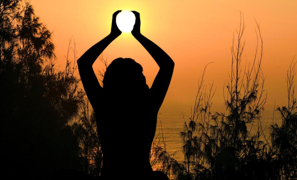 silhouette of woman Holding sun at water