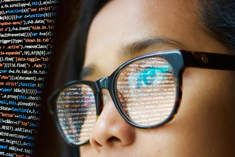 woman in glasses watching programming screen
