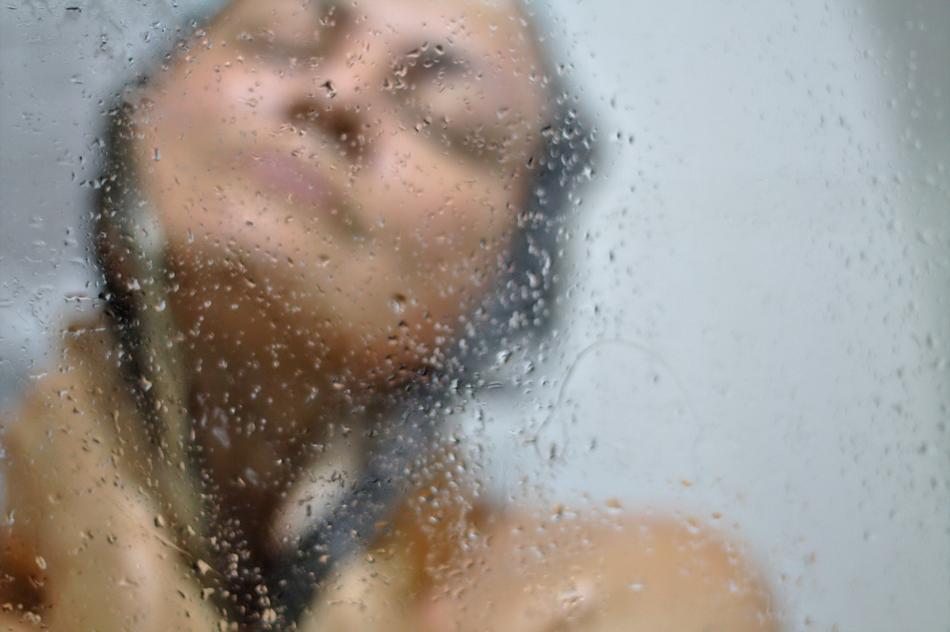 Bathing girl view through Wet glass