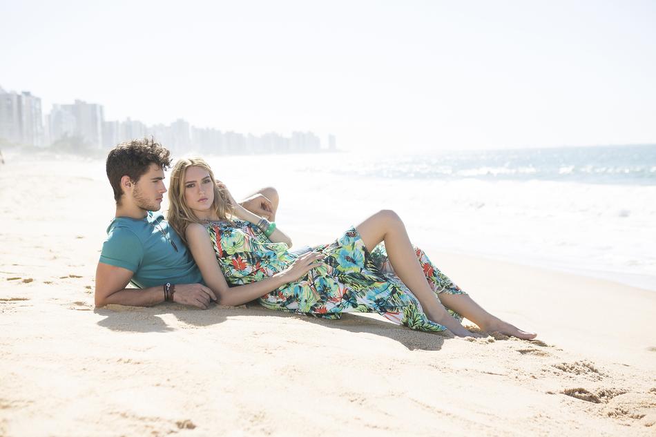 young couple rest on beach in view of city, Brazil