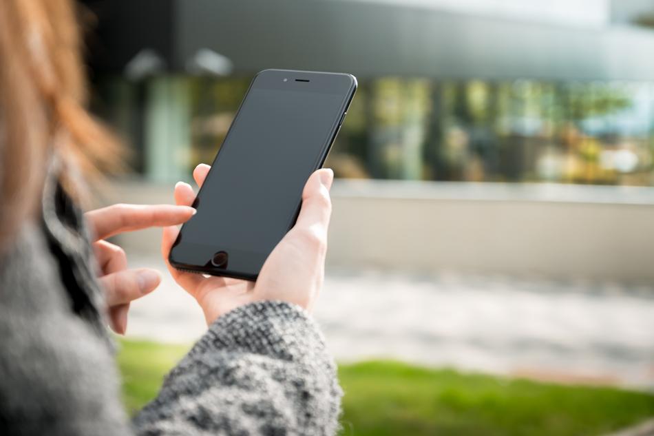 woman holding black smartphone