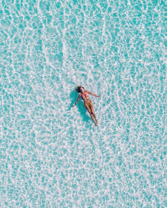 distant top vie of woman relaxing on water