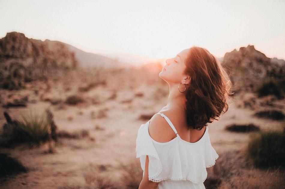relaxed young girl in white dress looking at sun