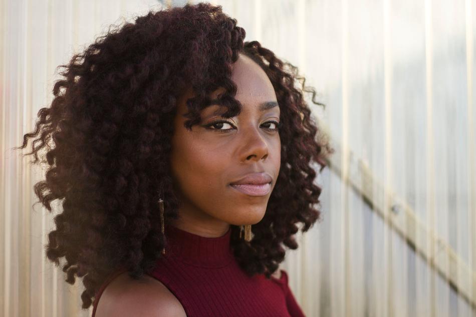 Portrait of the beautiful girl with curly hair and earrings