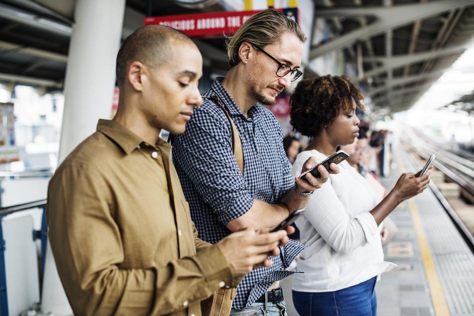 mand and woman with phones on a railway platform