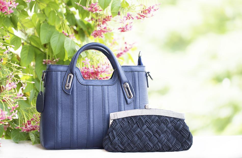 Lisaswardrobe women's handbags in the garden on a blurred background