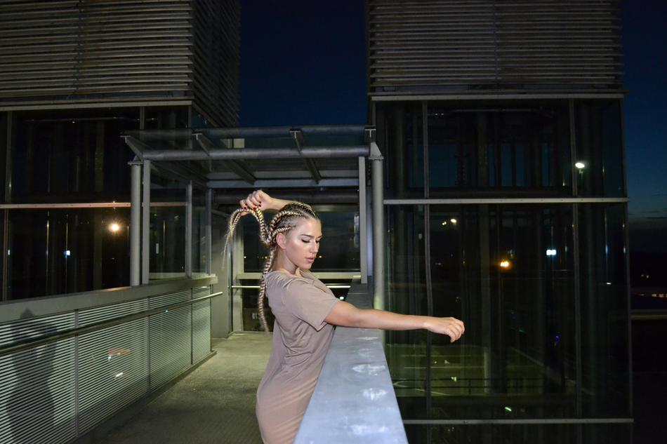 girl with pigtails in a fabric dress on the terrace