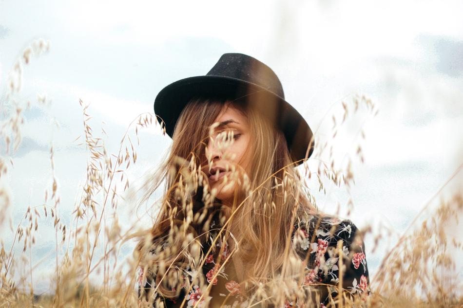 young Girl in black hat on meadow