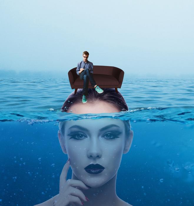 girl underwater has a sofa with a man on her head