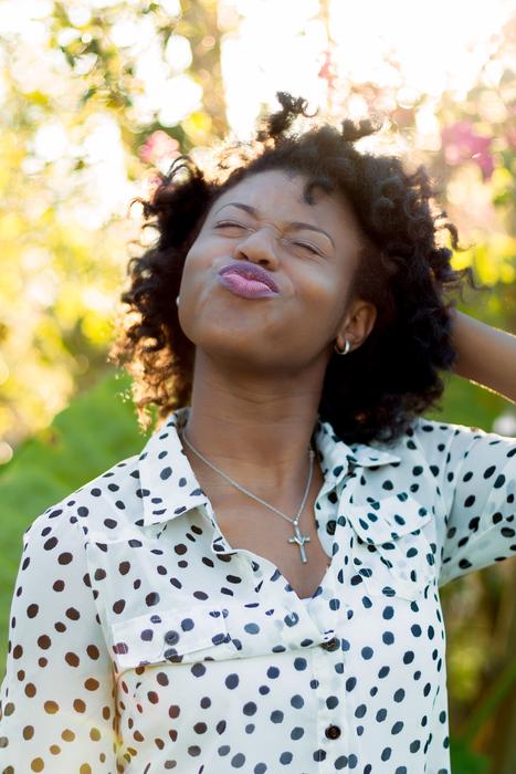 happy African woman on bright background with the plants