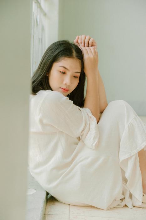 photo of asian girl in white suit without makeup