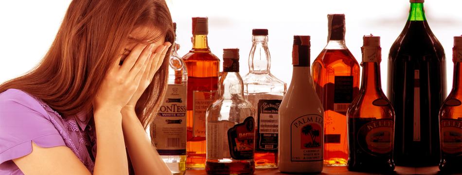 woman in despair on the background of bottles with alcohol