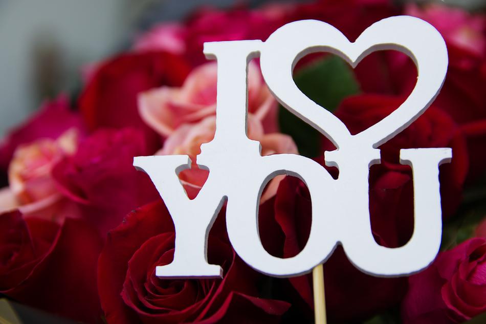 Beautiful, white 'I Love You' sign, near the colorful and beautiful roses