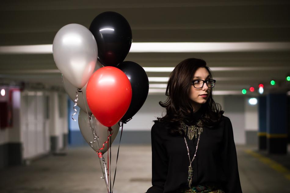 young girl in black clothing with bunch of Balloons