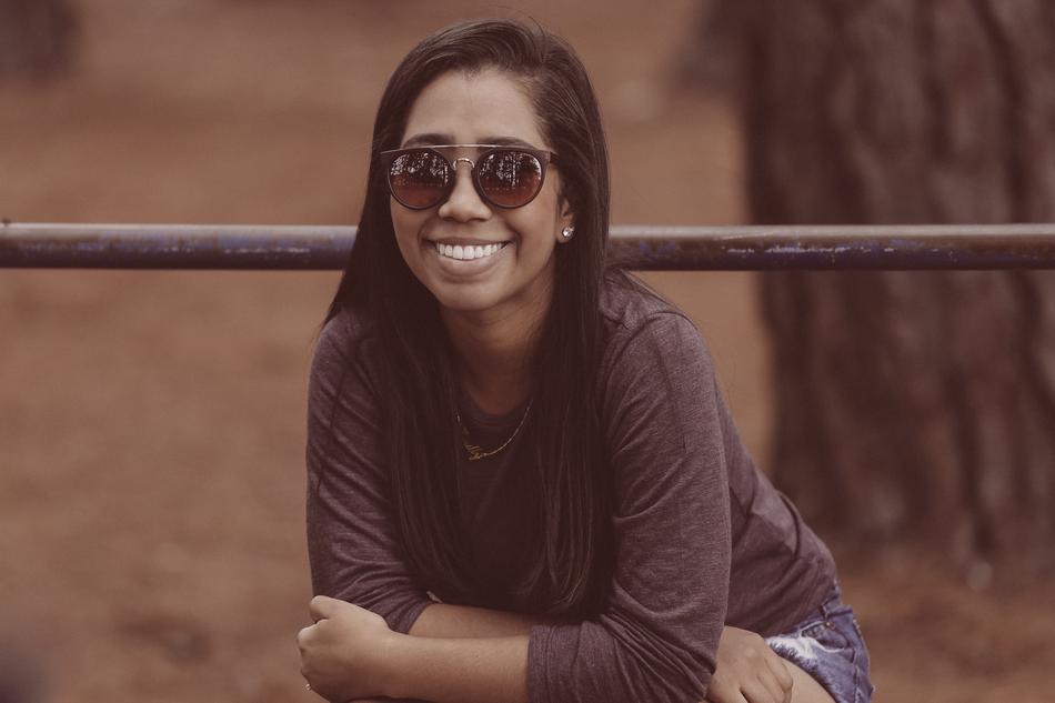 smiling girl in sunglasses on a blurred background