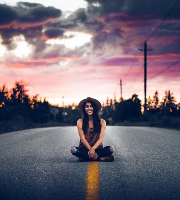 girl with hat on the highway at dusk
