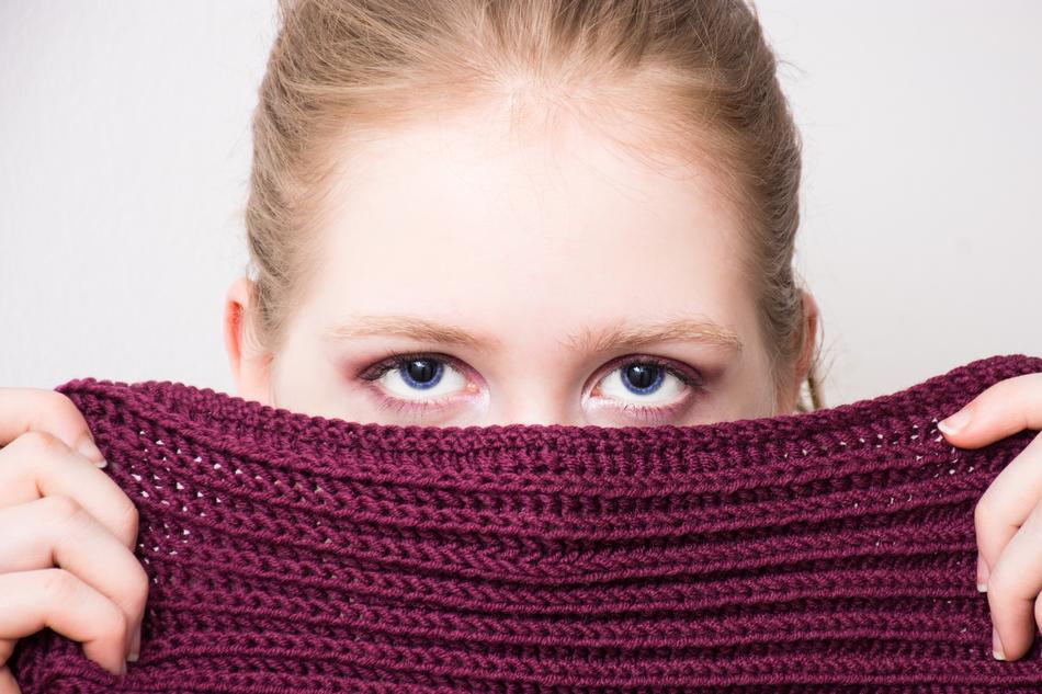 Portrait of a blonde woman with the beautiful knitting of burgundy color