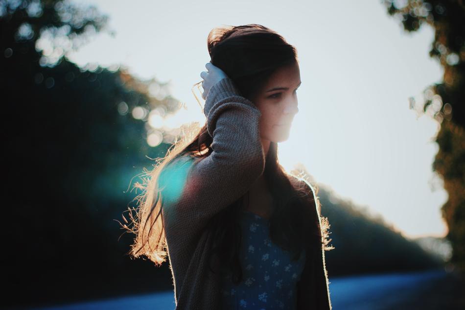 Posing girl among the trees at bright bokeh sunrise