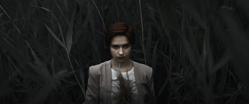 woman in tall grass in the dark