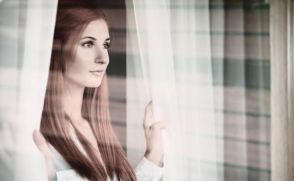 Young Woman at curtains
