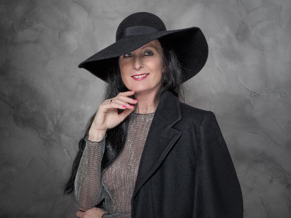 adult woman in a big black hat on a photo shoot