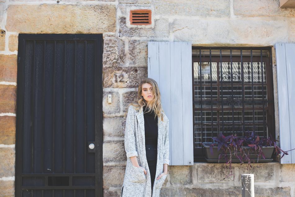 Beautiful, young, blonde woman, near the house, with the door and window