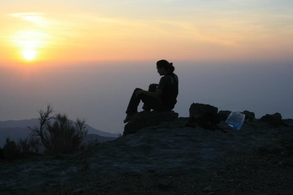 silhouette of a woman on top of a mountain at sunrise