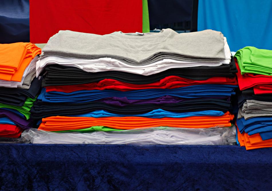stack of colorful T-shirts on the counter