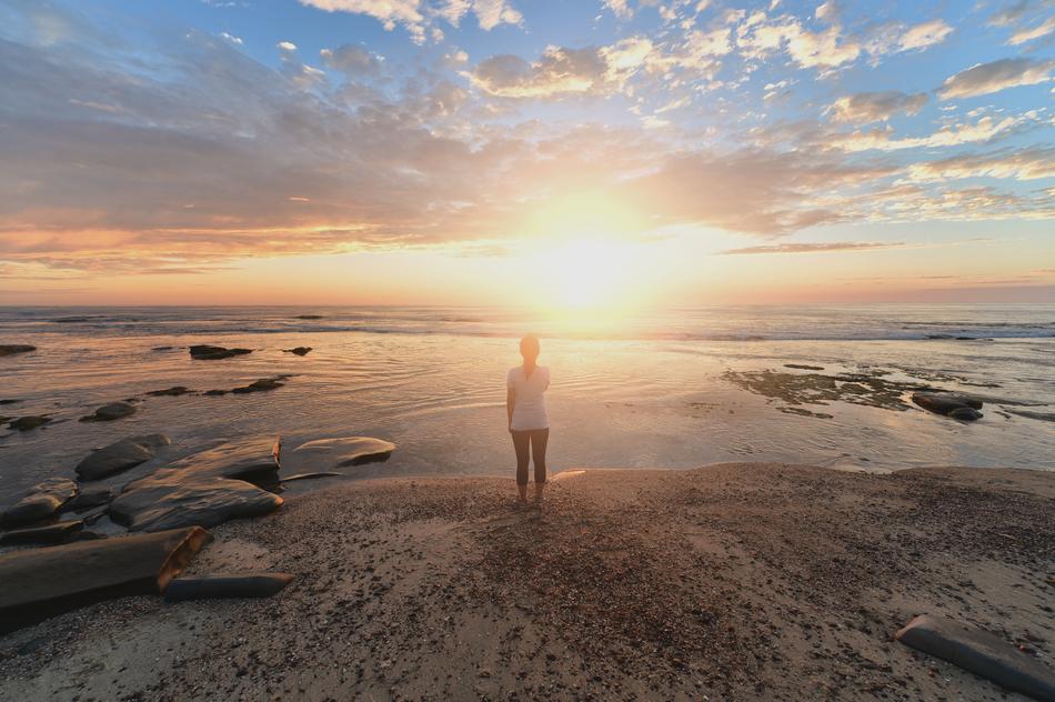girl on the coast in the rays of the setting sun
