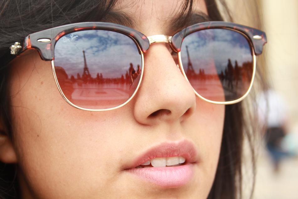 reflection of the eiffel tower in girls sunglasses