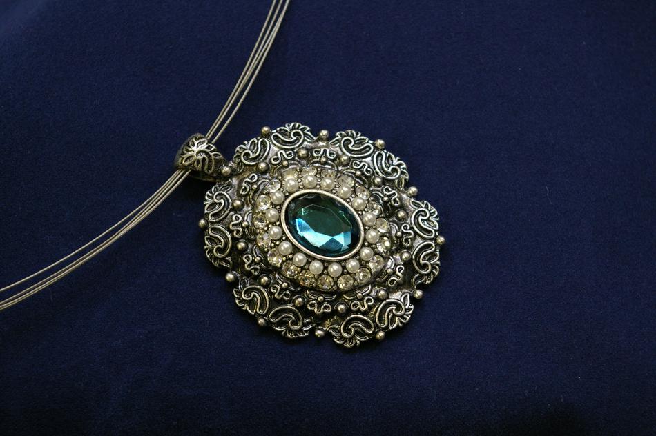 Close-up of the beautiful necklace with turquoise gem, at blue background