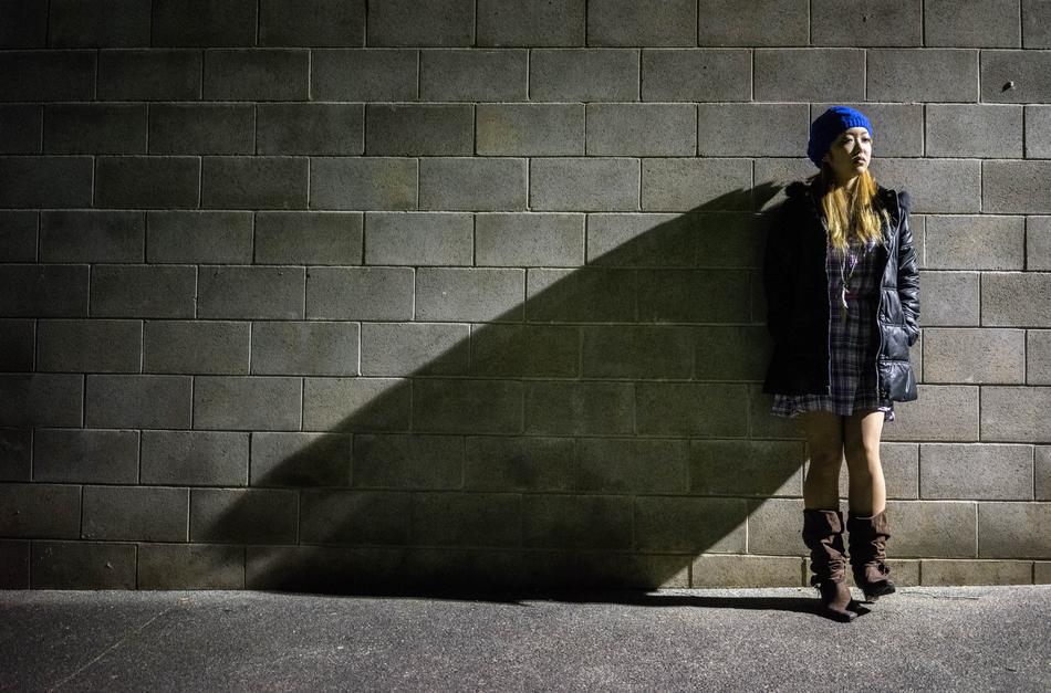 fashionable girl near a brick wall on a city street