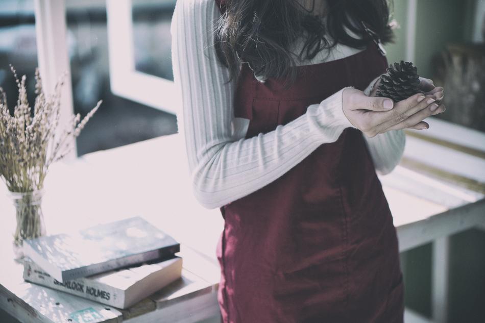 girl at the table with a pine cone in hand