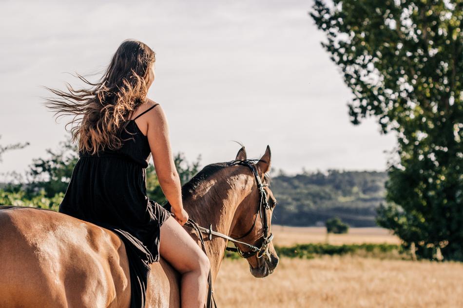 girl in a black dress on a horse
