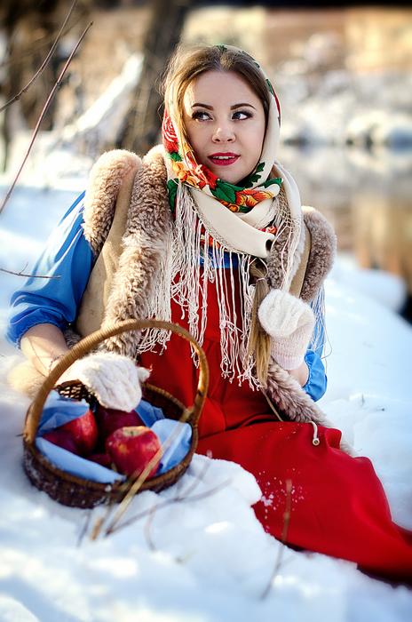 beautiful girl in folk costume in the snow