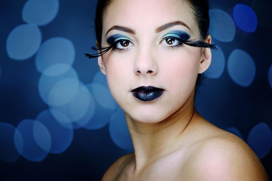 Portrait of the woman, with the blue makeup, at background with the blue bokeh lights