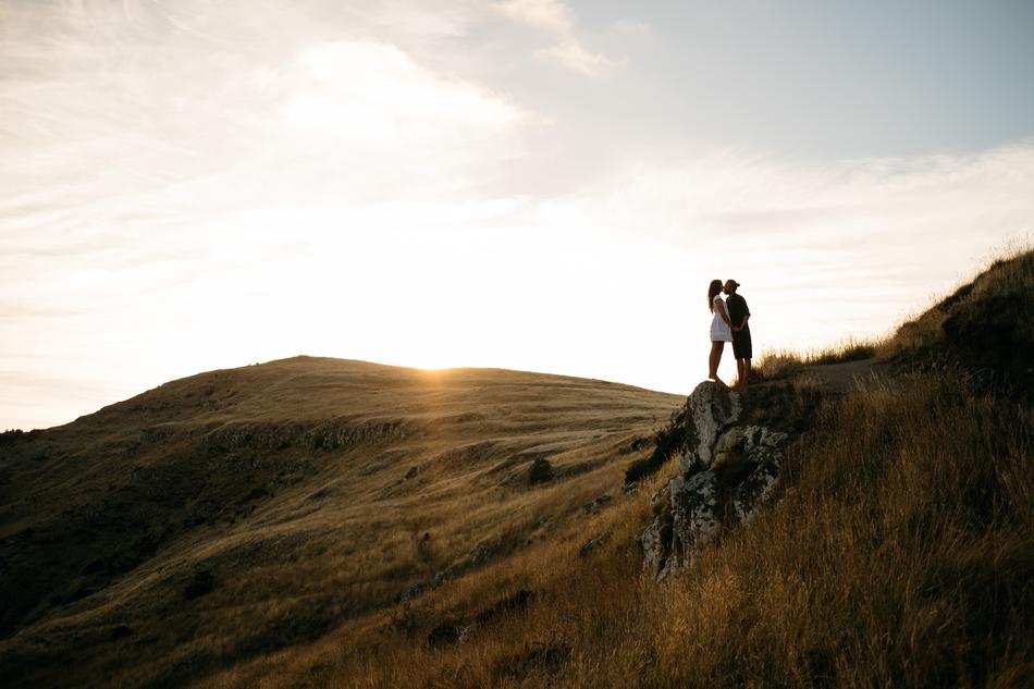 Couple, kissing on the beautiful and colorful mountains, at colorful sunset