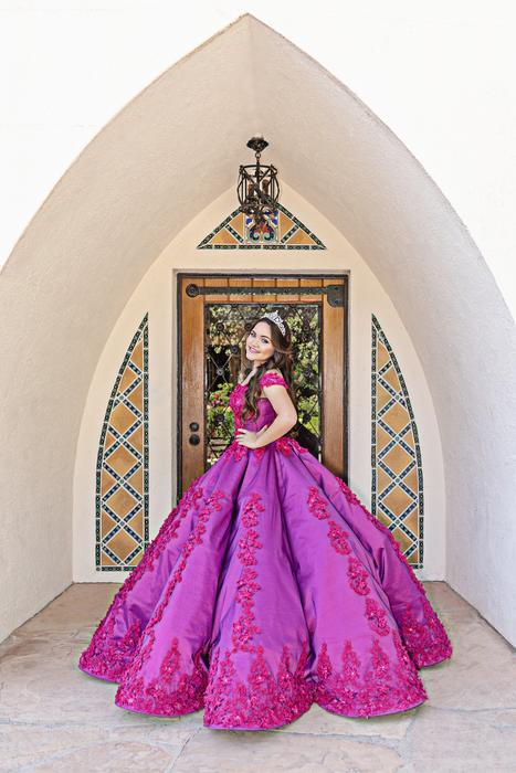 Beautiful and colorful girl in the beautiful, patterned, purple dress, on the Quinceañera, near the building