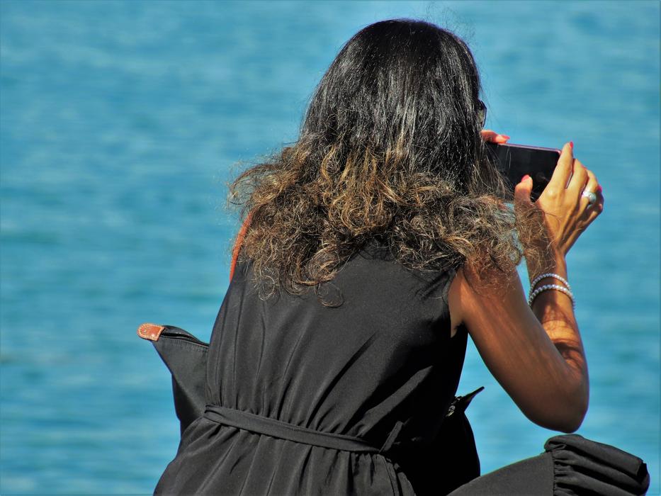 woman in black dress with phone